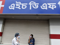 People talk on phone in front of HDFC bank in Kolkata, India, 18 June, 2021. HDFC Bank Ltd. expects IT spending to rise over the next two to...