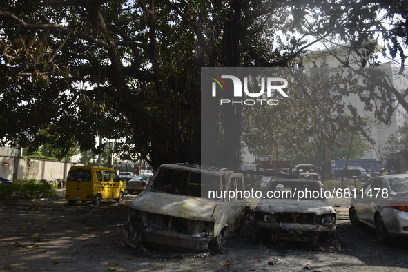 People stand next to wreckage of burnt cars after a gasoline tanker explosion on Mobolaji Bank Anthony way district of Lagos, on June 18, 20...