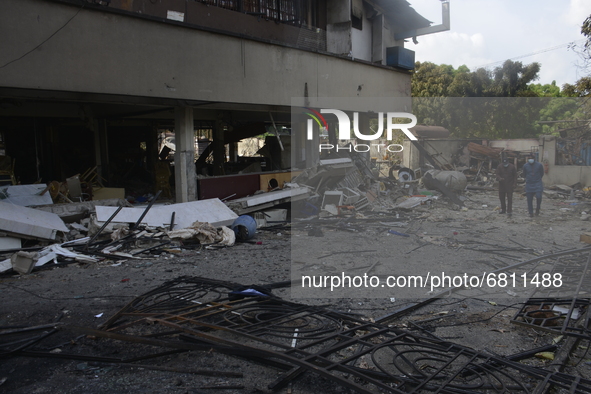 People walk past debris at the scene of a gasoline explosion on Mobolaji Bank Anthony way district of Lagos, on June 18, 2021. A tanker conv...