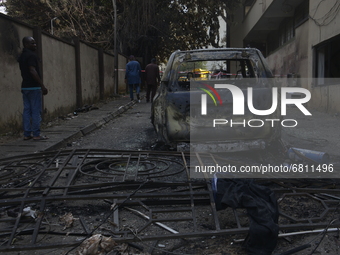 People walk past debris at the scene of a gasoline explosion on Mobolaji Bank Anthony way district of Lagos, on June 18, 2021. A tanker conv...