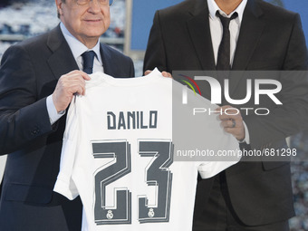 Brazilian Danilo (R) poses with Real Madrid's President Florentino Perez as they hold Danilo's jersey during his presentation as new player...