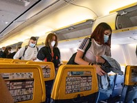Passengers during the flight wear a facemask in the cabin. Flying during the Covid-19 Coronavirus pandemic inside a Boeing 737-800 aircraft...
