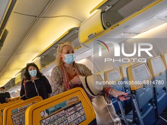 Passengers during the flight wear a facemask in the cabin. Flying during the Covid-19 Coronavirus pandemic inside a Boeing 737-800 aircraft...