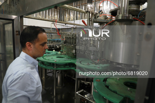 A Palestinian employee cleans an empty production line at the PEPSI factory in Gaza's industrial zone on June 21, 2021. - Israel lifted some...