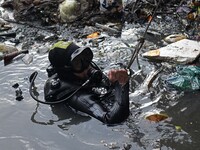 A Rescue worker is seen conducting search operations at Jhilpar sewer in the capital Dhaka, Bangladesh on June 22, 2021. (