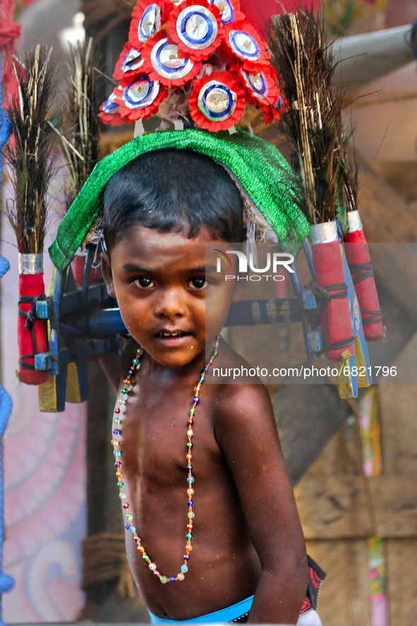 Tamil Hindu boy performs the kavadi attam ritual while circling the exterior of the temple as an act of penance during the Amman Ther Thiruv...