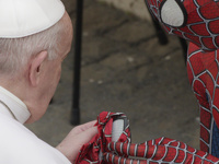 Pope Francis meets Spider-Man, who presents him with his mask, at the end of his weekly general audience with a limited number of faithful i...
