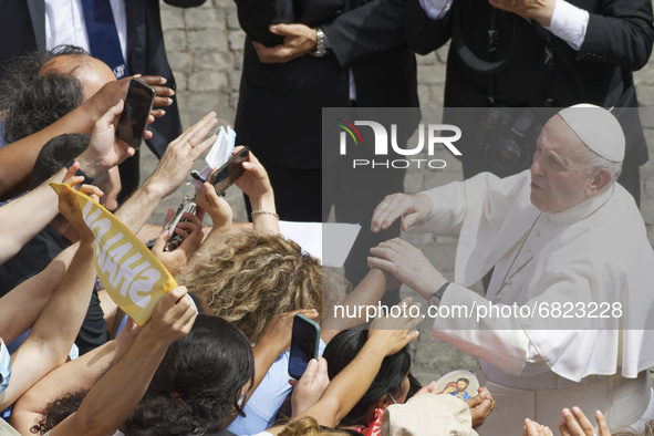 Pope Francis salutes faithful as he arrives for his weekly general audience with a limited number of faithful in the San Damaso Courtyard at...