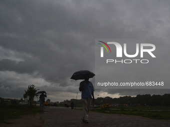 An indian man walks on a pathway during rains in Allahabad,on July 10,2015. (