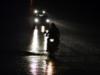 An indian motorcyclist rides on a pathway during rains in Allahabad,on July 10,2015. (