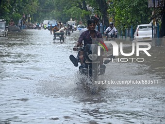 Indian young  people enjoy the bike ride  in  the waterlogged street due to heavy rain in Kolkata, India on  Friday, July 10, 2015. (