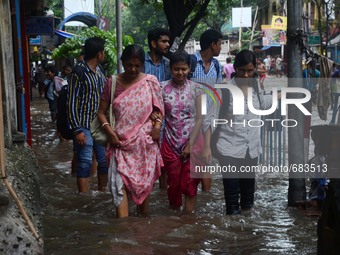 Indian women walking  along  the waterlogged street due to heavy rain in Kolkata, India on  Friday, July 10, 2015. (
