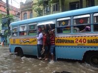 Indian daily passengers  on the way to their work place in a bus  along  the waterlogged street due to heavy rain in Kolkata, India on  Frid...