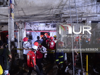Firefighters rescuers inspect the scene after a suspected gas explosion in a central neighbourhood in the Bangladesh capital Dhaka which has...