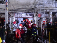 Firefighters rescuers inspect the scene after a suspected gas explosion in a central neighbourhood in the Bangladesh capital Dhaka which has...