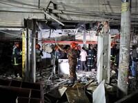 Fire rescue workers inspect the site after a massive blast occurred in a shop that killed several people in Dhaka, Bangladesh on June 27, 20...