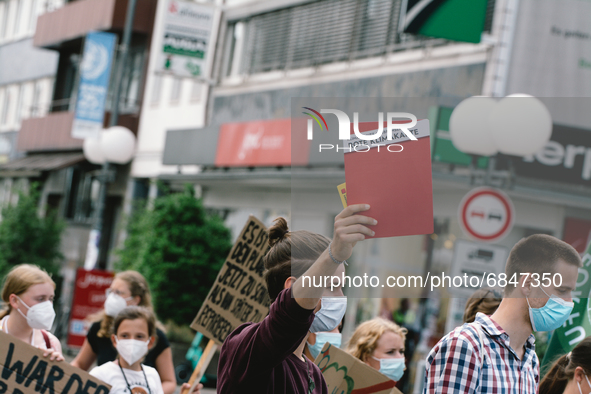 an activist holds a red card during the Fridays for Future demo in Bonn, Germany on July 2, 2021 for better climate protection 