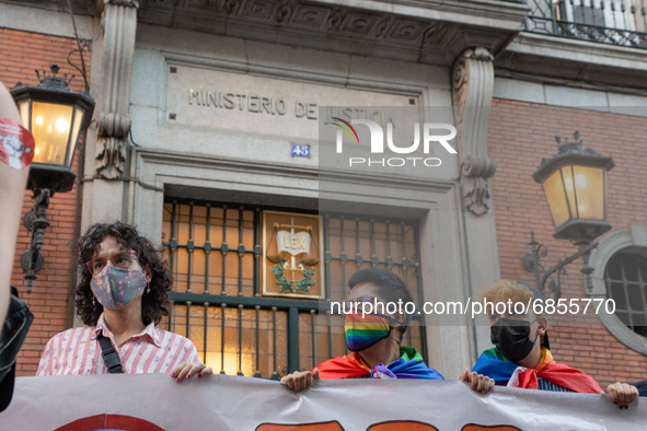 Three people hold a banner in front of the ministry of justice in Madrid, Spain, on July 5, 2021 during a protest following the murder of Sa...