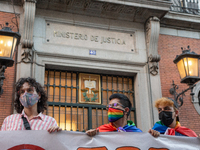 Three people hold a banner in front of the ministry of justice in Madrid, Spain, on July 5, 2021 during a protest following the murder of Sa...