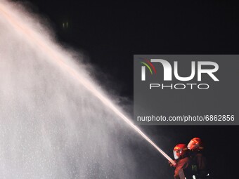 Firefighters work at the scene of a fire that broke out at a factory named Hashem Foods Ltd. in Rupganj of Narayanganj district, outskirts o...