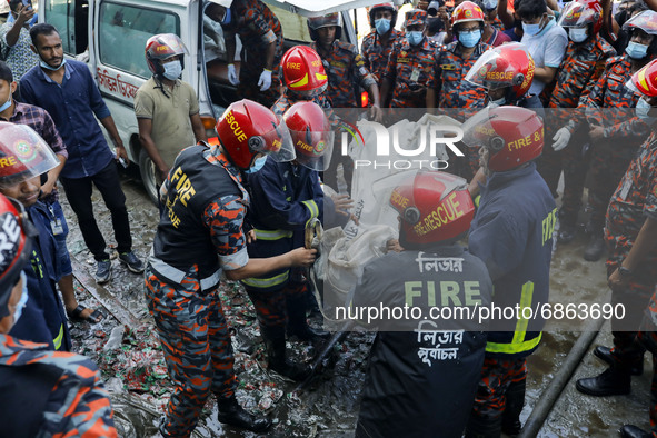 Rescue workers carry the bodies that were recovered after a fire broke out at a factory of Hashem Foods Ltd in Rupganj, Narayanganj district...