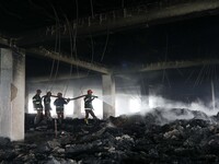 Firefighters work at the site of a fire that broke out on Thursday at Hashem Foods Ltd factory in Rupganj, Narayanganj district, on the outs...