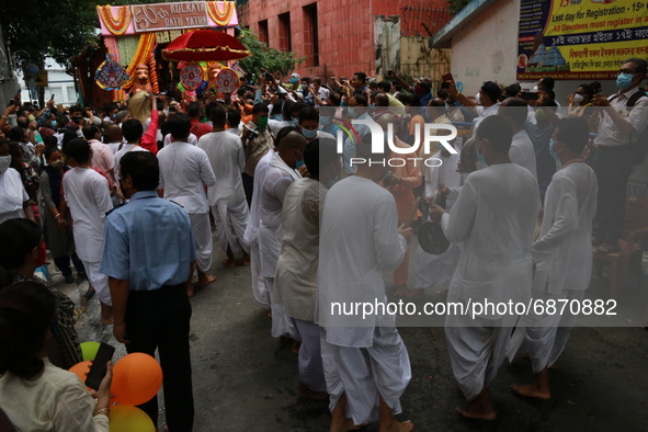 Temple priests and Hindu devotees carry an idol of Lord Jagannath as a symbolic gesture after the Rath Yatra procession was cancelled amid c...
