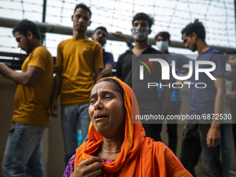 Relatives of the victims mourn at the site where a fire broke out at Hashem Foods Ltd in Rupganj, on the outskirts of Dhaka, Bangladesh, Jul...