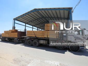 Trucks loaded with goods enter the Gaza Strip from Israel through the Kerem Shalom crossing in Rafah in the southern Gaza Strip on July 14,...