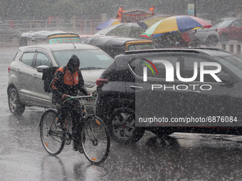 Commuters are seen on the road at a sudden monsoon rain downpour time in the eastern Indian state odisha's capital city Bhubaneswar, India,...