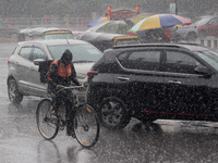 Commuters are seen on the road at a sudden monsoon rain downpour time in the eastern Indian state odisha's capital city Bhubaneswar, India,...
