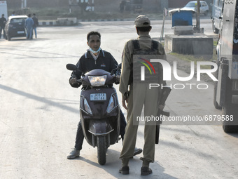 An Indian policeman stops a civilian during a military operation in Srinagar, Indian Administered Kashmir on 16 July 2021. Two militants wer...