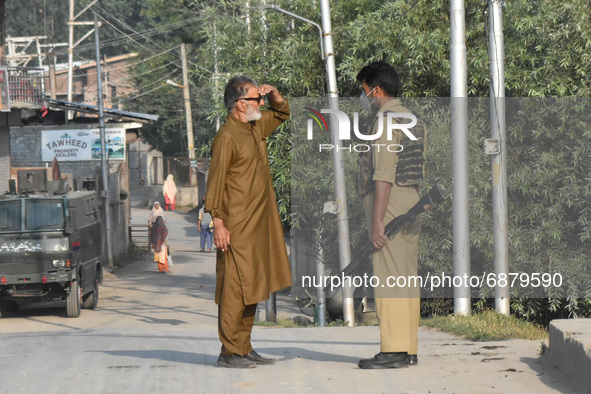 An Indian policeman stops a civilian during a military operation in Srinagar, Indian Administered Kashmir on 16 July 2021. Two militants wer...