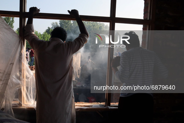 Kashmiri People try to douse the fire at a damaged residential house where two Militants were killed in a military operation in Srinagar, In...
