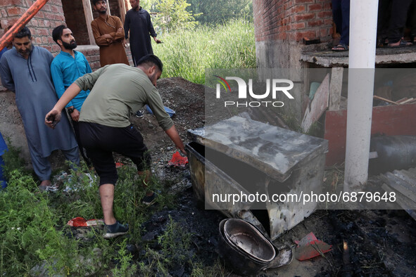 A Kashmiri man recovers the remains from a damaged residential house where two Militants were killed in a military operation in Srinagar, In...