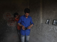 Kashmiri People assess the damaged residential house where two Militants were killed in a military operation in Srinagar, Indian Administere...