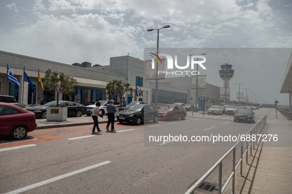 Exterior of the departure area and the control tower of Athens Airport. Passengers with face masks as seen at Athens International Airport A...
