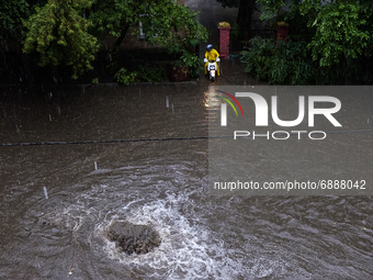 Food courier on a flooded street during a heavy downpour in Kyiv, Ukraine. July 19, 2021  (