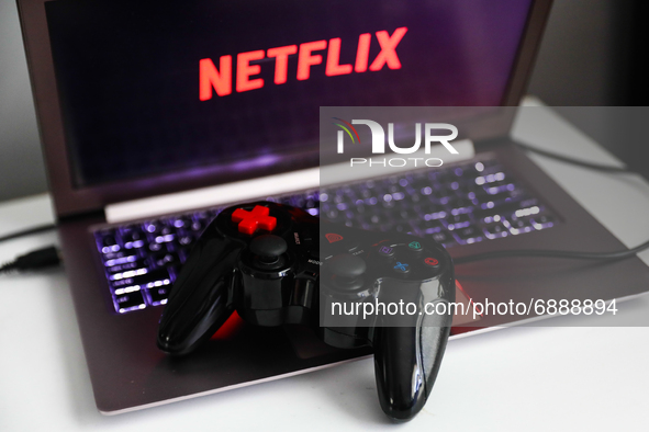 Netflix logo displayed on a laptop screen and a gamepad are seen in this illustration photo taken in Krakow, Poland on July 19, 2021. 