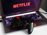 Netflix logo displayed on a laptop screen and a gamepad are seen in this illustration photo taken in Krakow, Poland on July 19, 2021. (