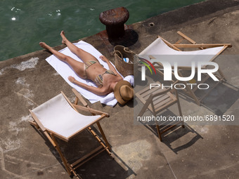 A woman enjoys sunbathing in San Sebastian, on July 20, 2021. Beachgoers have gathered at the beaches on San Sebastian, Spain at temperature...