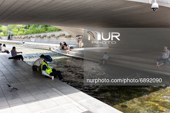 People take a break around the Cheonggyecheon Stream to avoid the heat on July 21, 2021 in Seoul, South Korea. Today, the temperature in Seo...