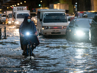 A cyclist wades through a flooded street following heavy rains in Manila,  Philippines, on July 21, 2021.(