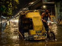 A pedicab driver wades through a flooded street following heavy rains in Manila,  Philippines, on July 21, 2021.(