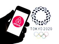 In this photo illustration a Airbnb, Inc. logo seen displayed on a smartphone with a Tokyo 2020 Olympic Games logo in the background. (