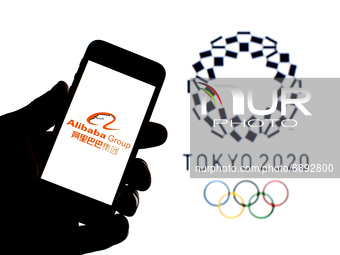 In this photo illustration a Alibaba Group logo seen displayed on a smartphone with a Tokyo 2020 Olympic Games logo in the background. (