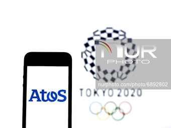 In this photo illustration a Atos logo seen displayed on a smartphone with a Tokyo 2020 Olympic Games logo in the background. (