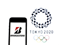 In this photo illustration a Bridgestone logo seen displayed on a smartphone with a Tokyo 2020 Olympic Games logo in the background. (
