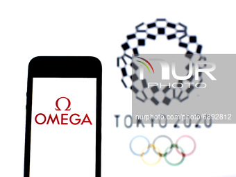 In this photo illustration a Omega SA logo seen displayed on a smartphone with a Tokyo 2020 Olympic Games logo in the background. (