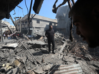 Palestinian  policemen  and firefighters gather at the scene of a blast in Gaza City, the cause of which has not yet been determined, on Jul...